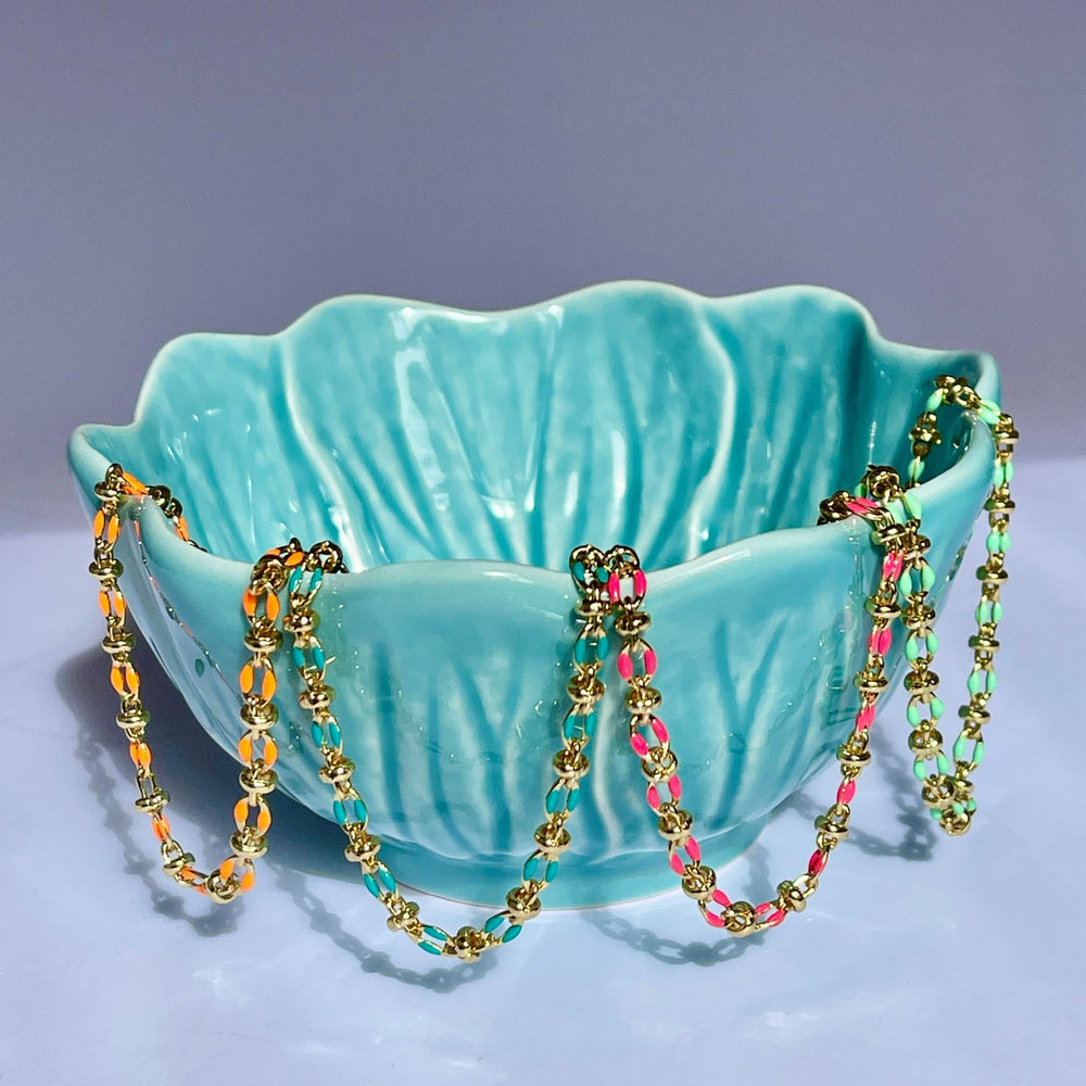 
                  
                    4 colourful enamel bracelet draped over a teal coloured bowl
                  
                