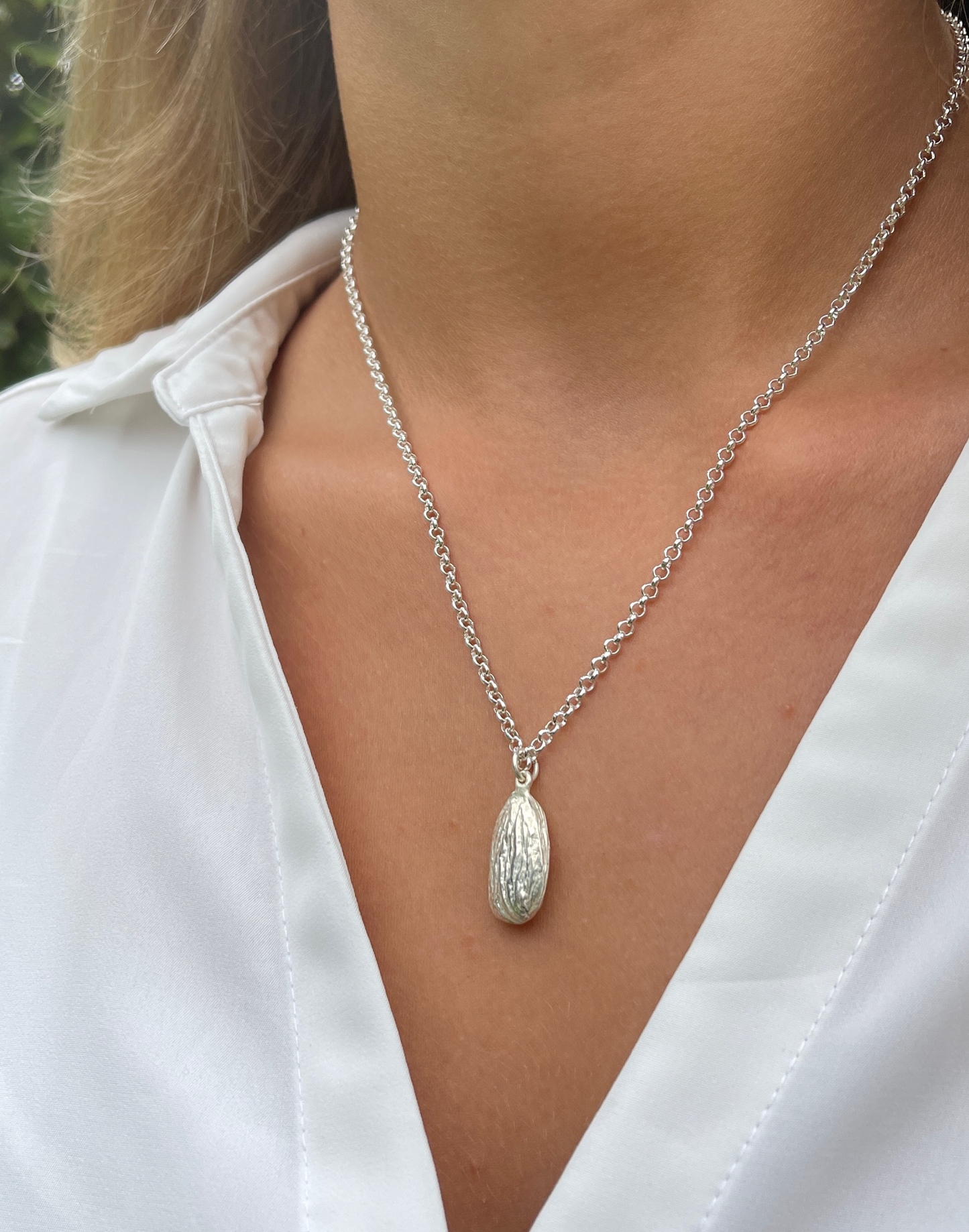 model weears almond silver pendant necklace