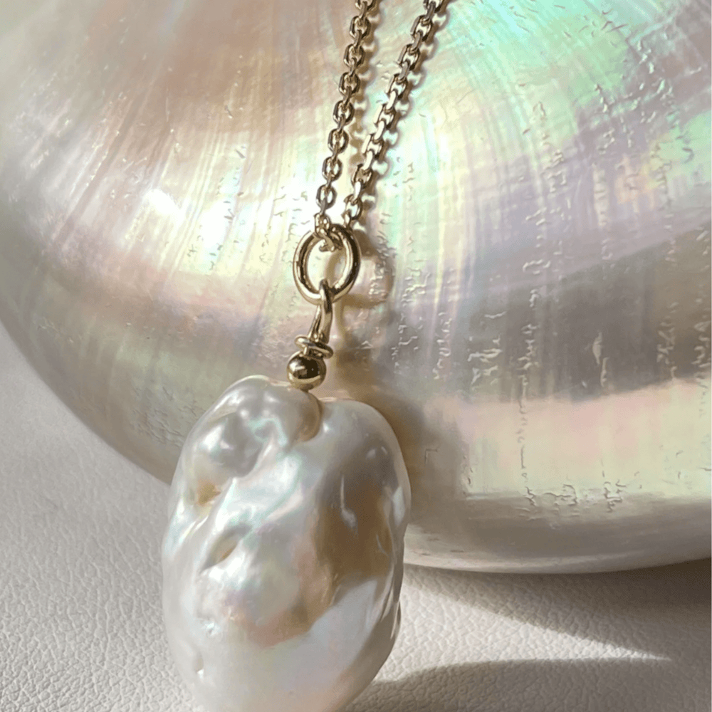 
                  
                    Baroque pearl charm pendant on shell
                  
                
