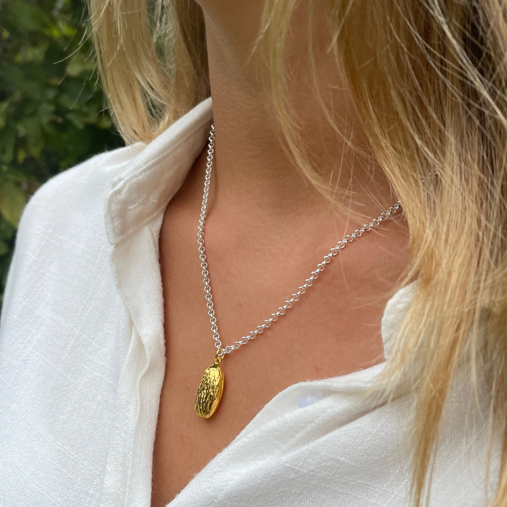 gold almond necklace on silver chain on model