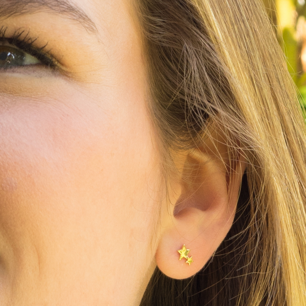 model wears gold double star studs