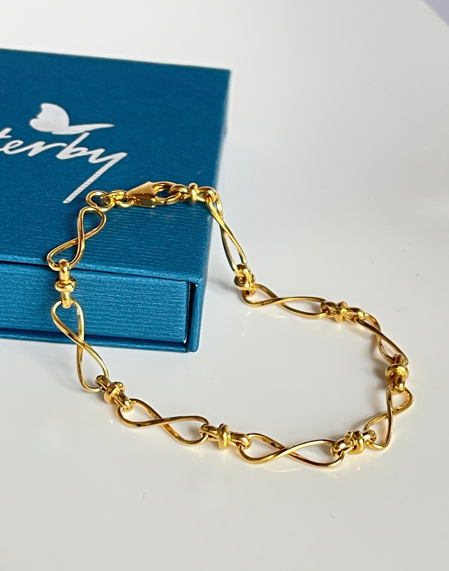 gold infinity bracelet on tile