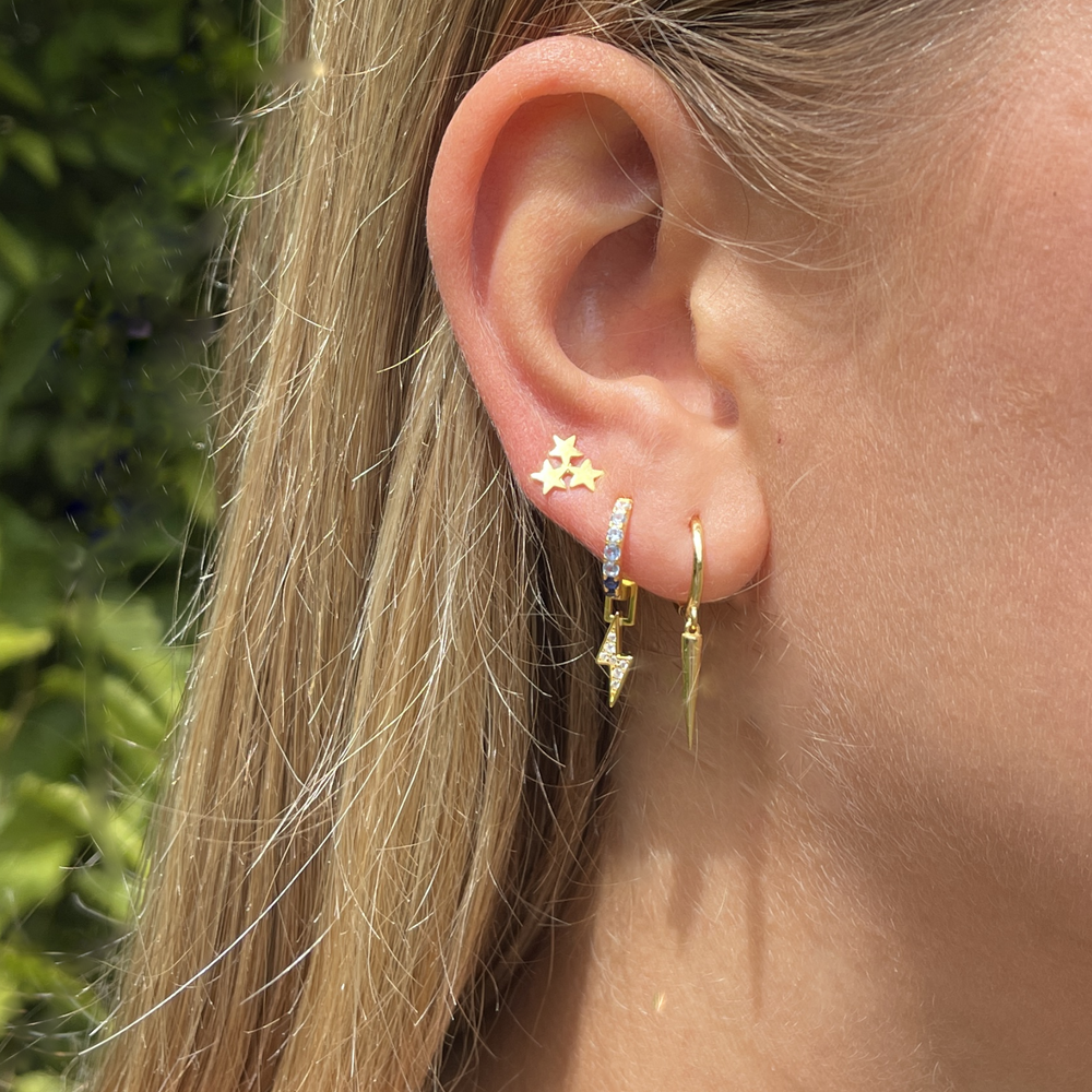 model wears gold long cone huggie earrings