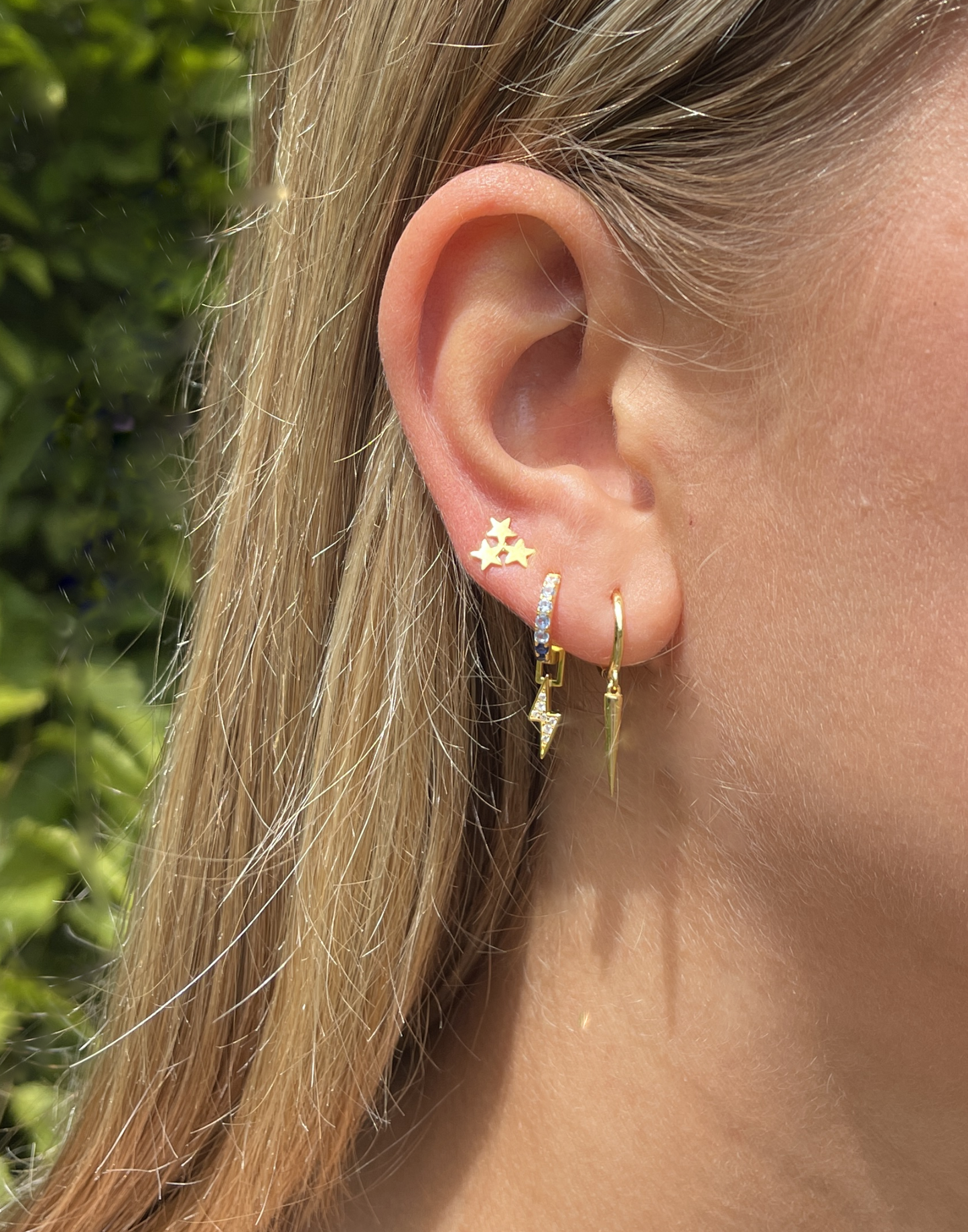model wears gold long cone huggie earrings