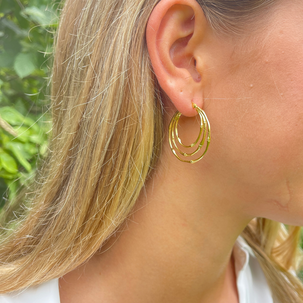 
                  
                    model wears gold multi ring hoops
                  
                