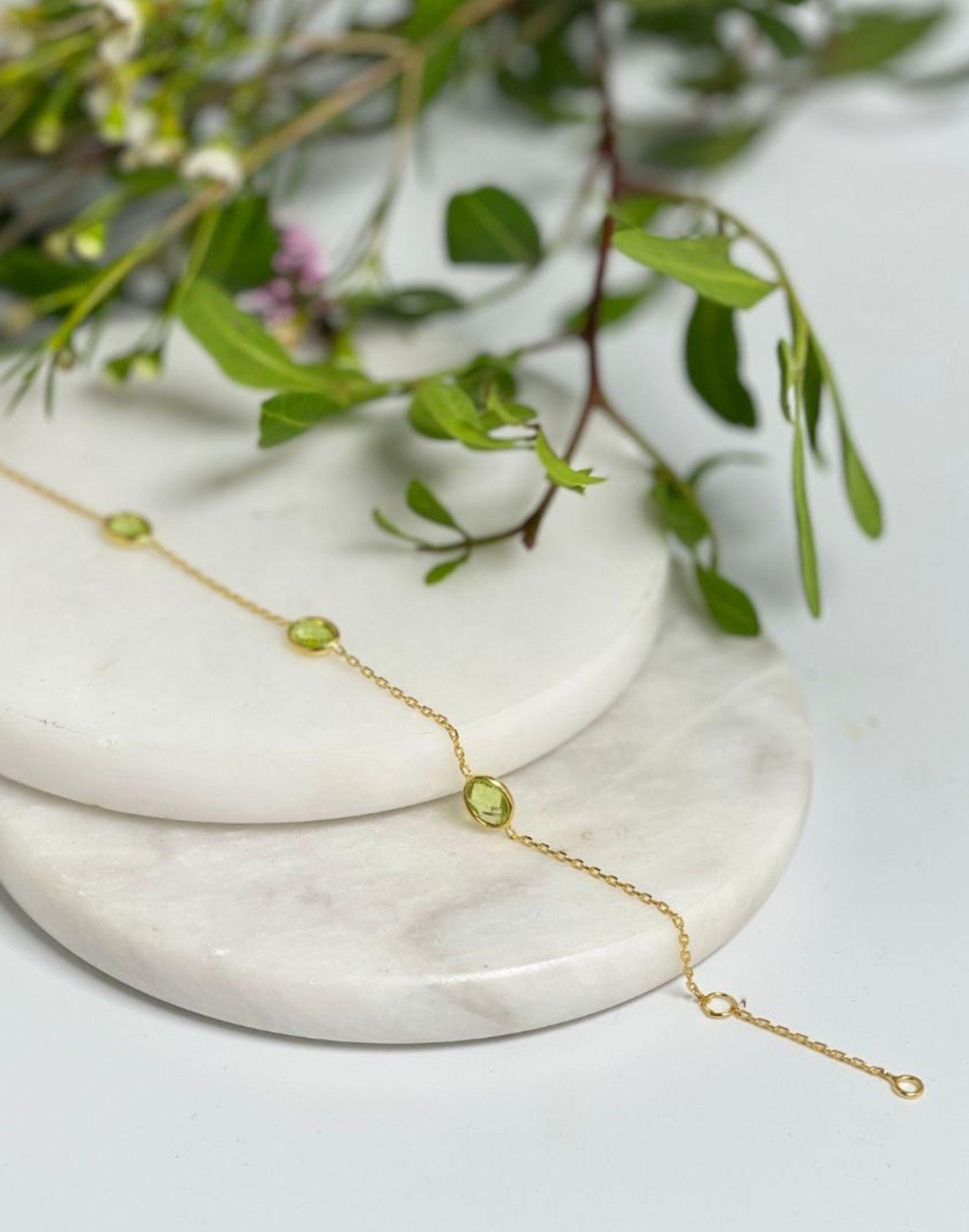 Gold peridot bracelet on tile