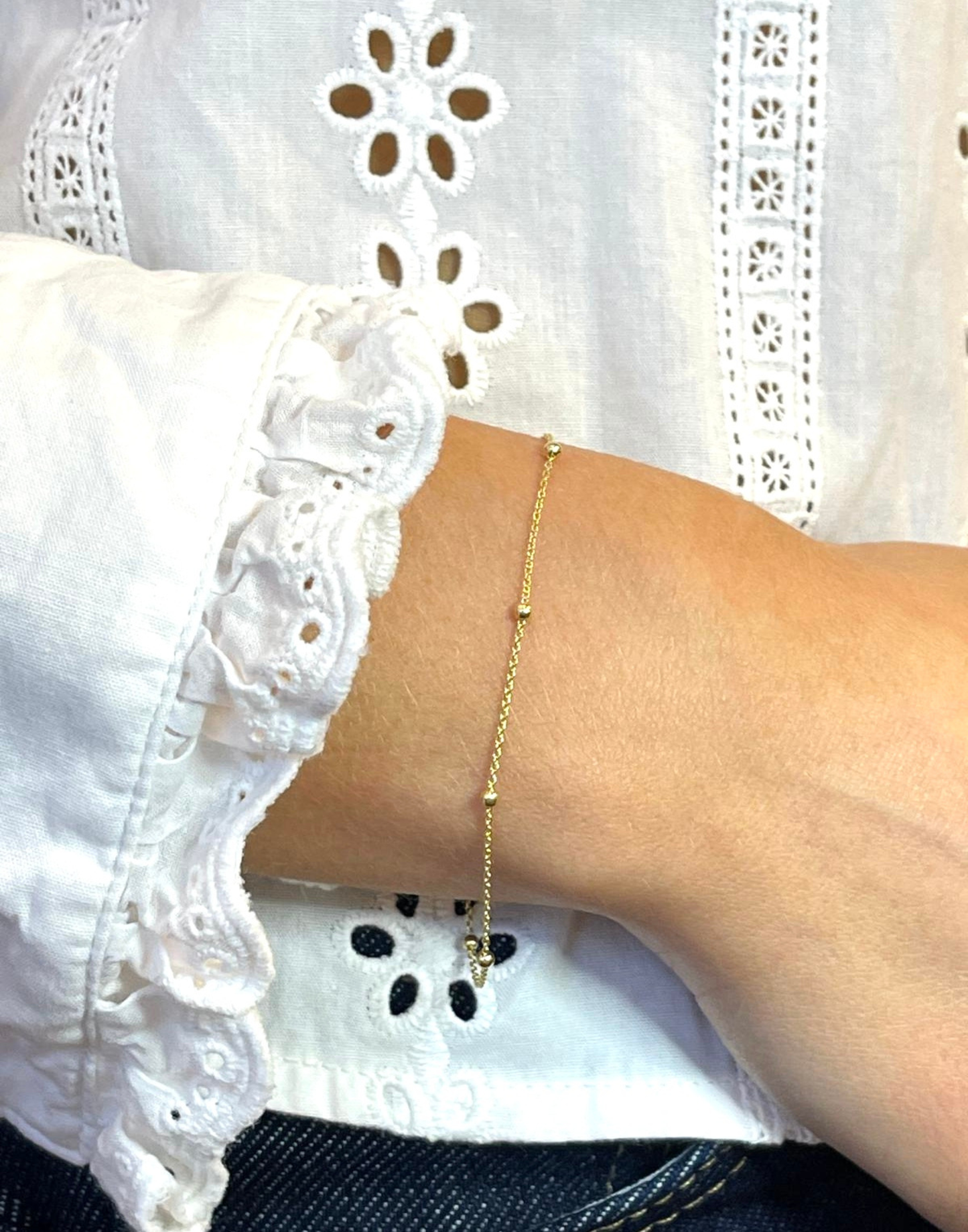 Model wears gold satellite bracelet