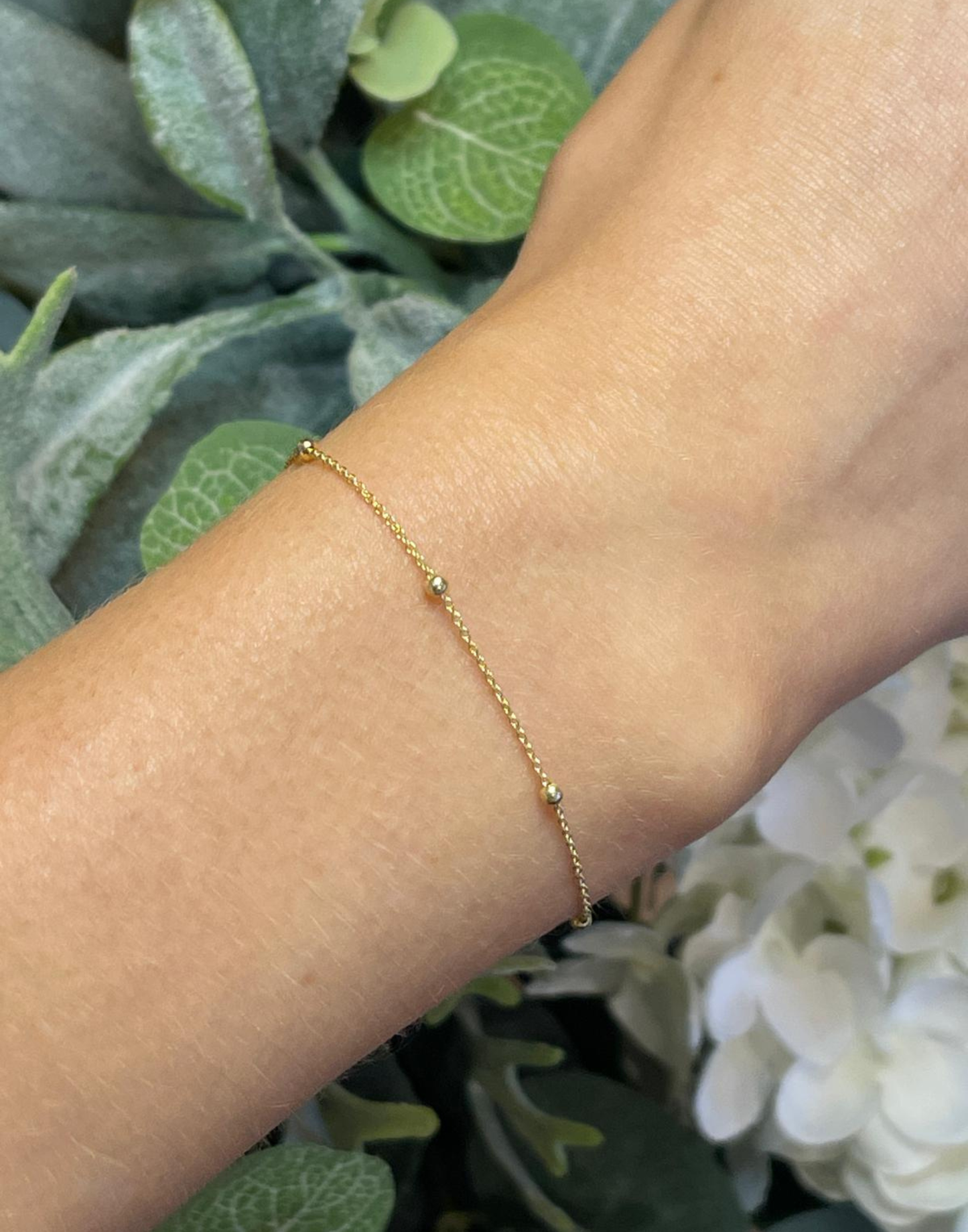 Model wears gold satellite bracelet