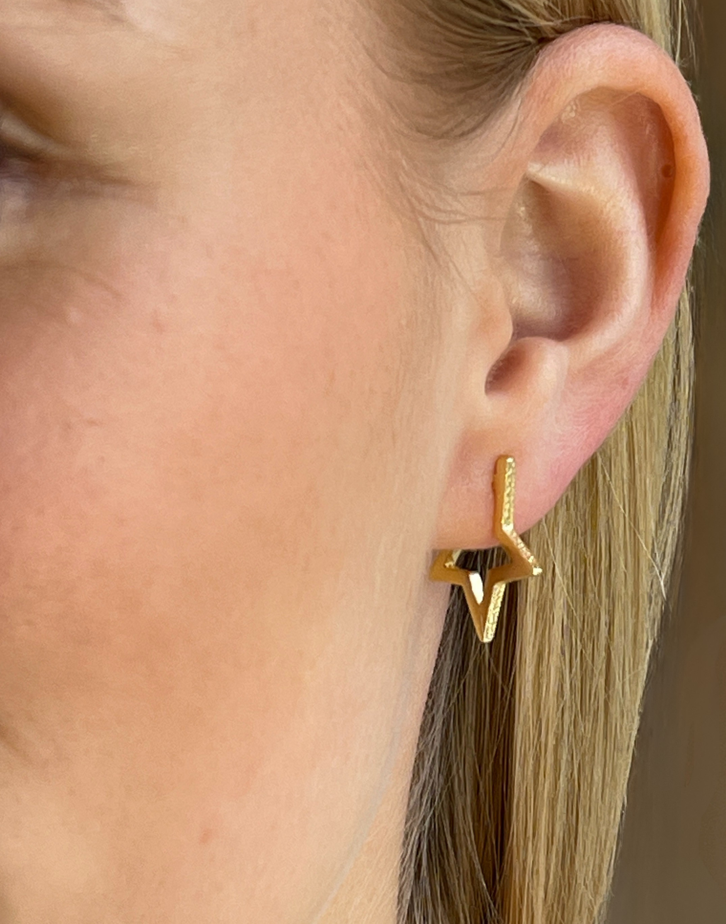 model wears gold star hoop earrings