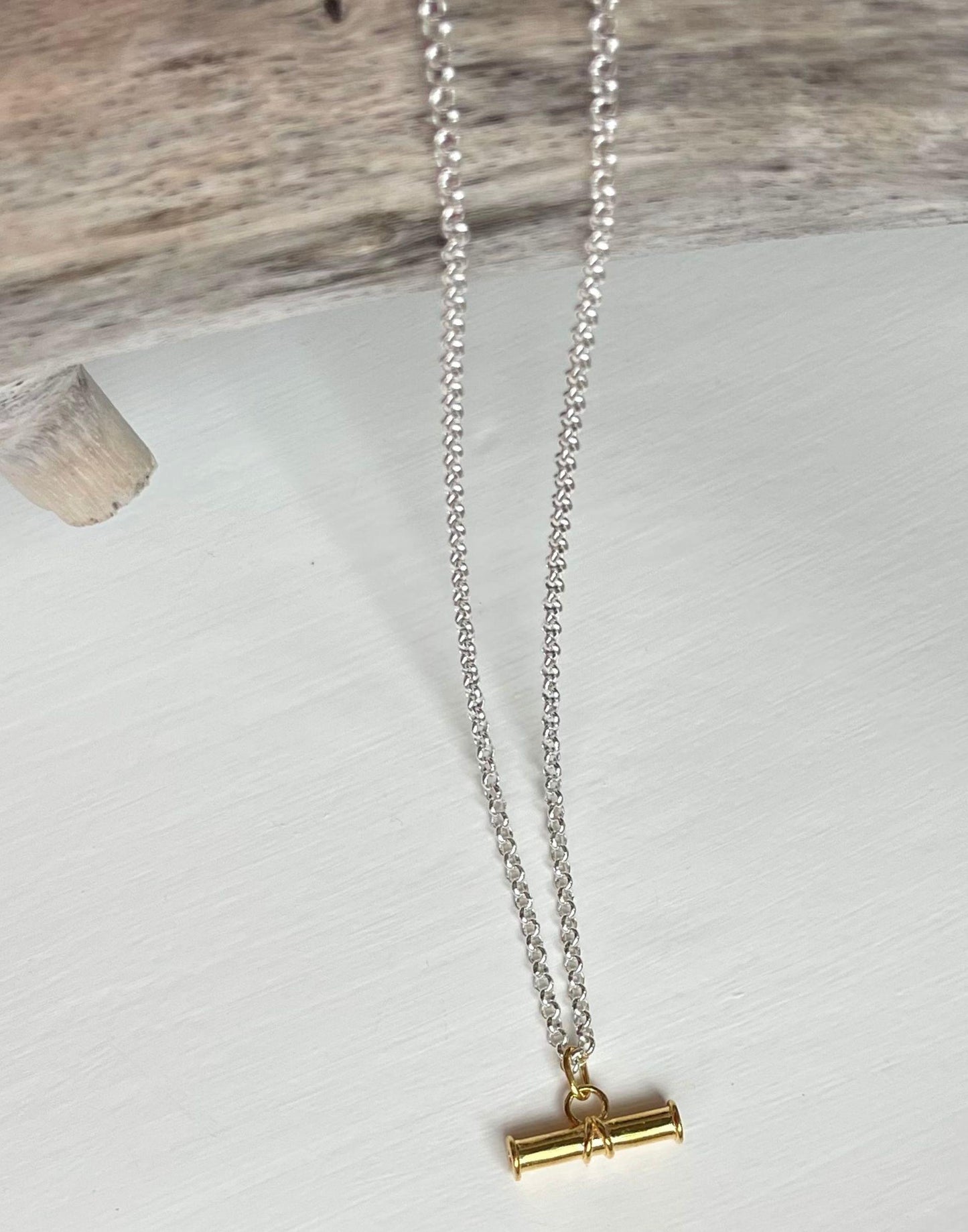 Gold T Bar on Silver Belcher Chain Necklace draped over driftwood