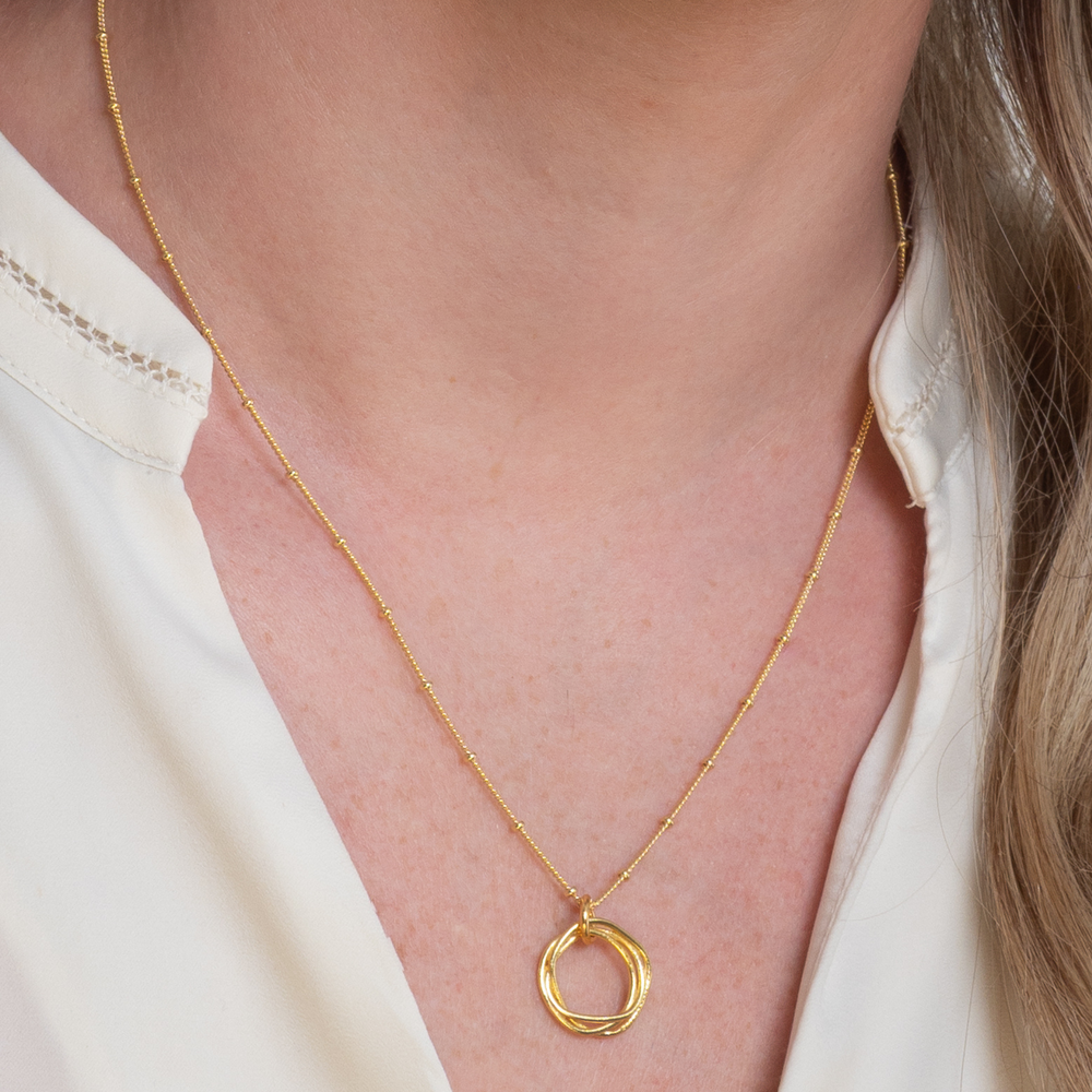 
                  
                    model wears gold twisted circle necklace
                  
                