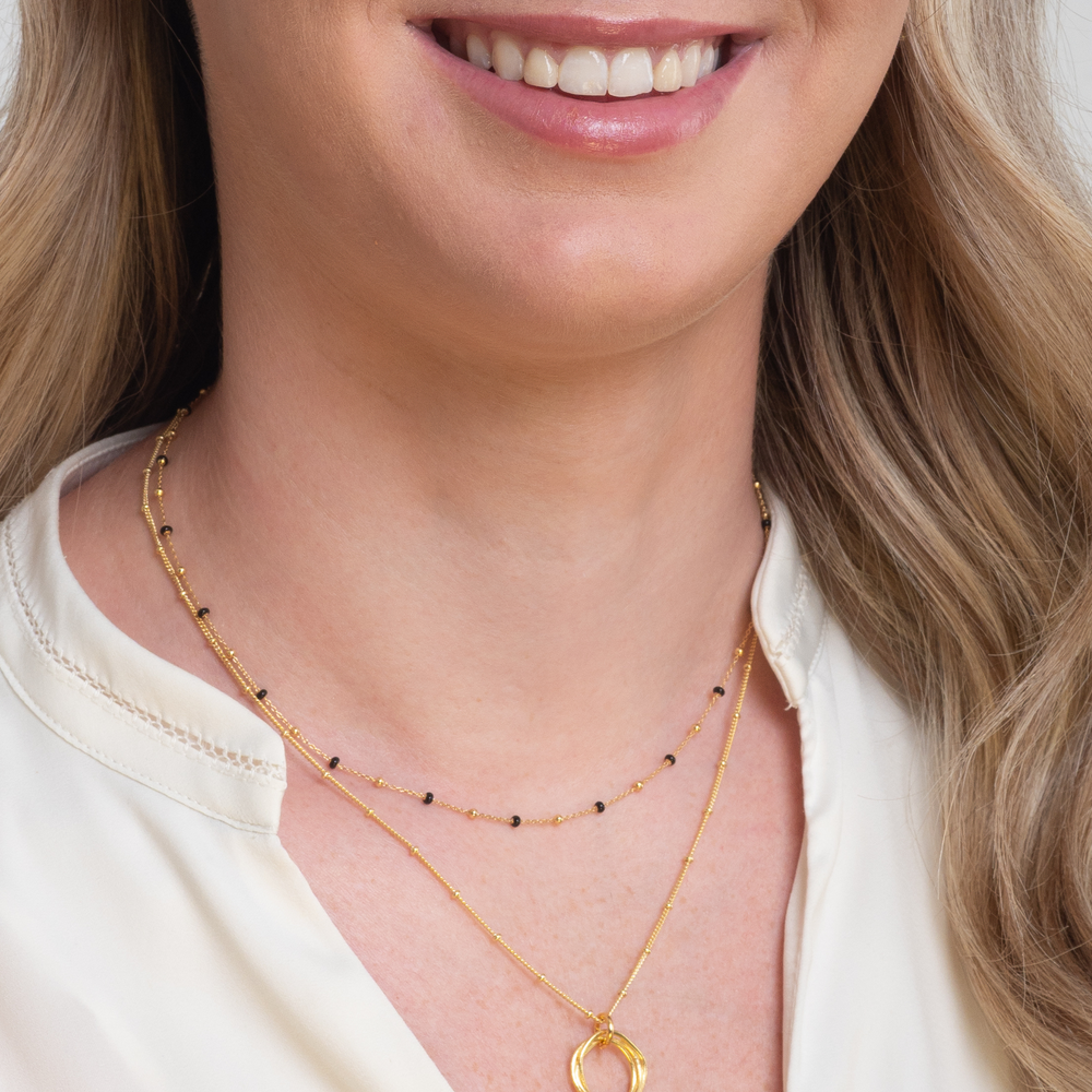 
                  
                    model wears gold twisted circle necklace layered
                  
                