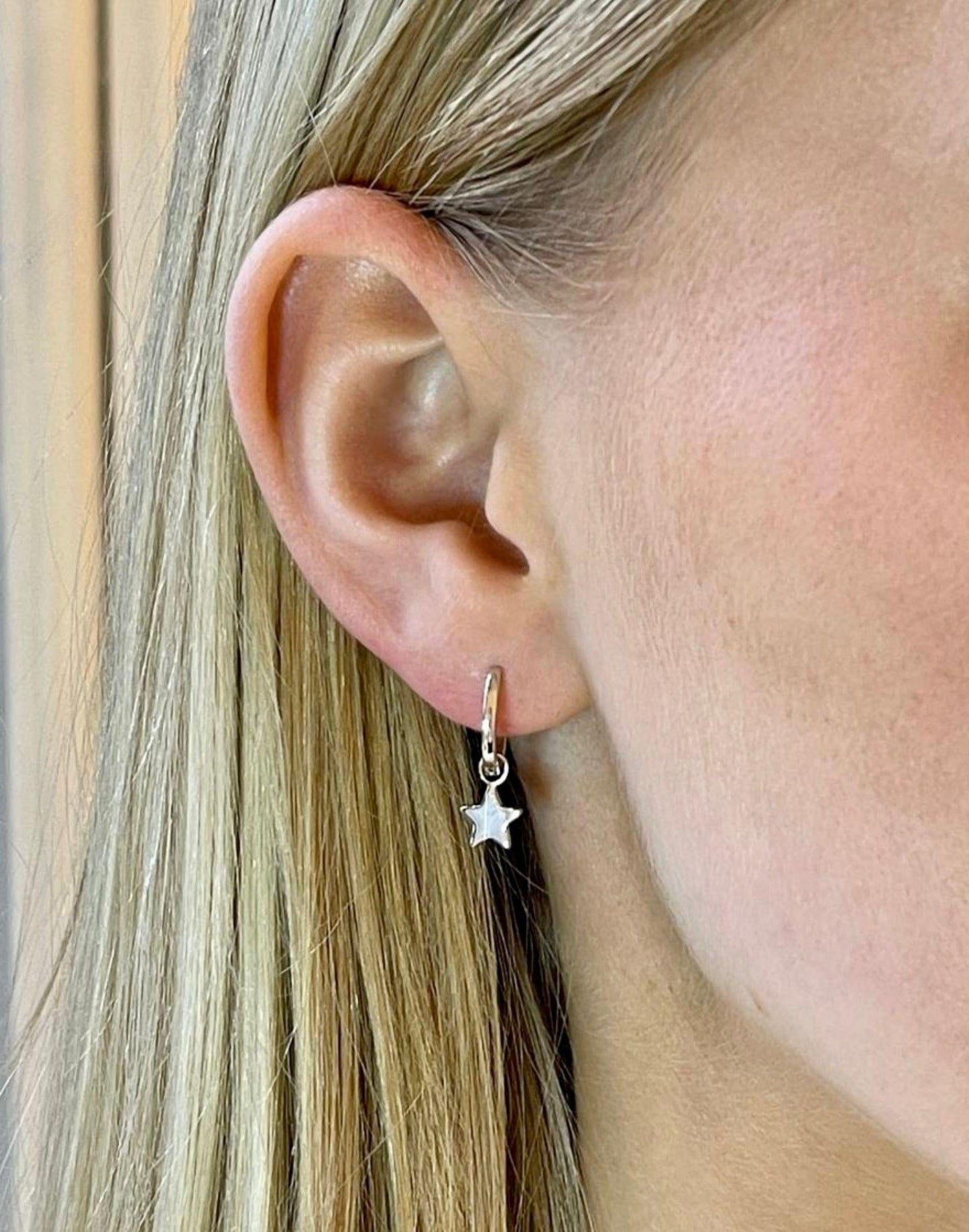 model wears hannah silver star charm huggie earrings
