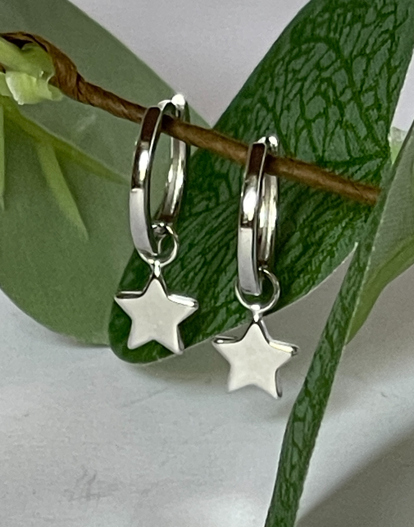 Silver huggie earrings with small star charm