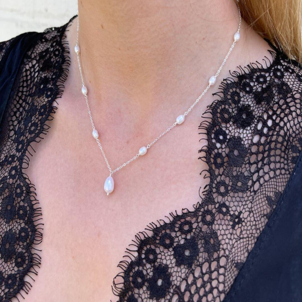 
                  
                    silver and pearl drop necklace on model
                  
                