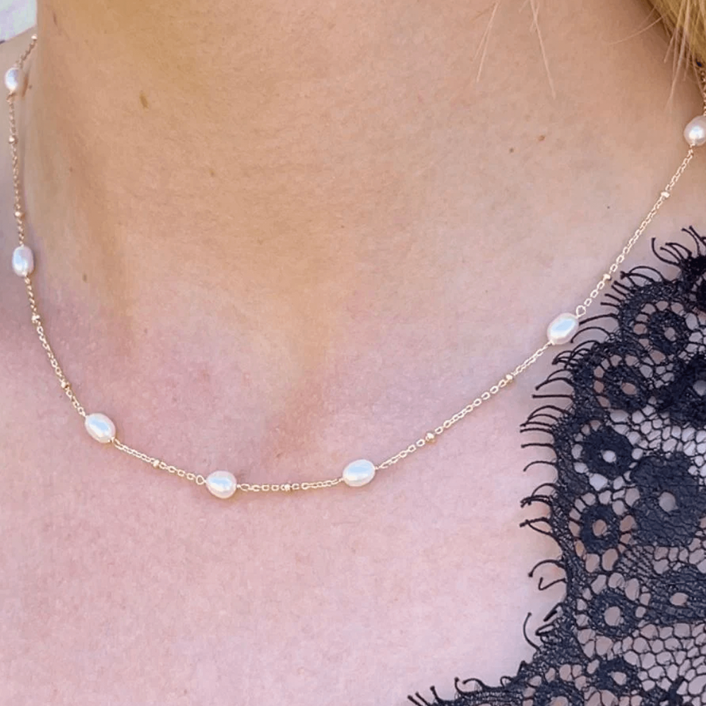Gold and pearl necklace worn on model