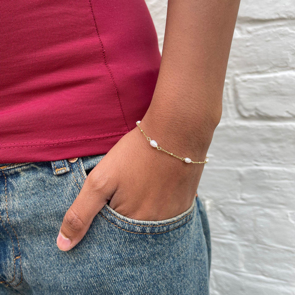 Model wears Helena Pearl and gold bracelet