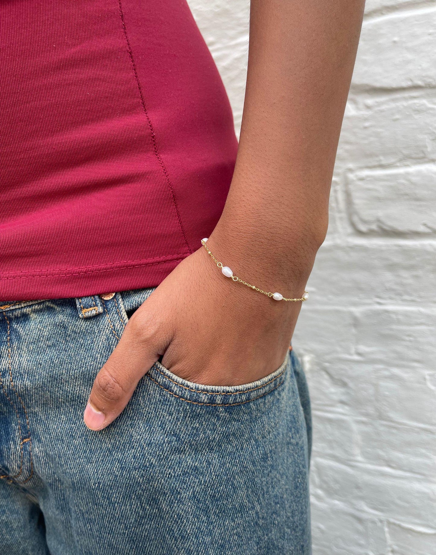 Model wears Helena Pearl and gold bracelet