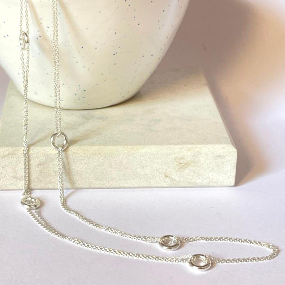 Silver Hoopla Necklace draped over a bowl