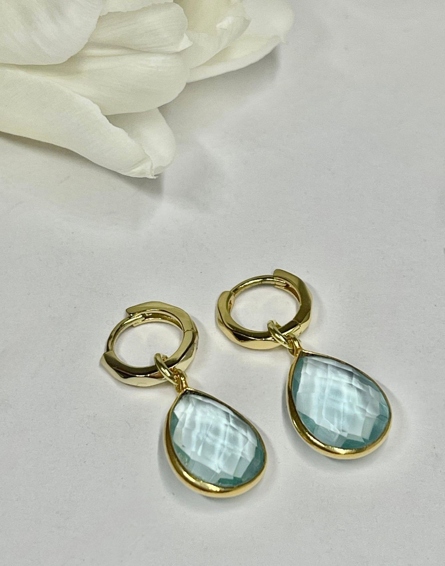 Kiera blue topaz drop earrings on a tile next to a Flutterby gift box