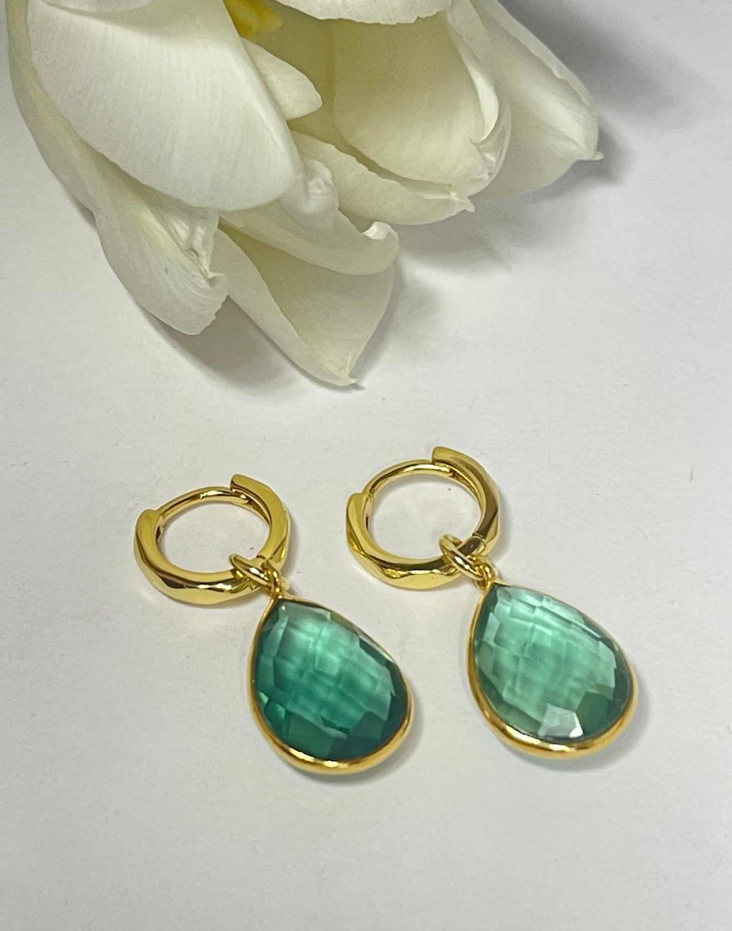 Kiera forest green drop earrings on a tile next to a Flutterby gift box