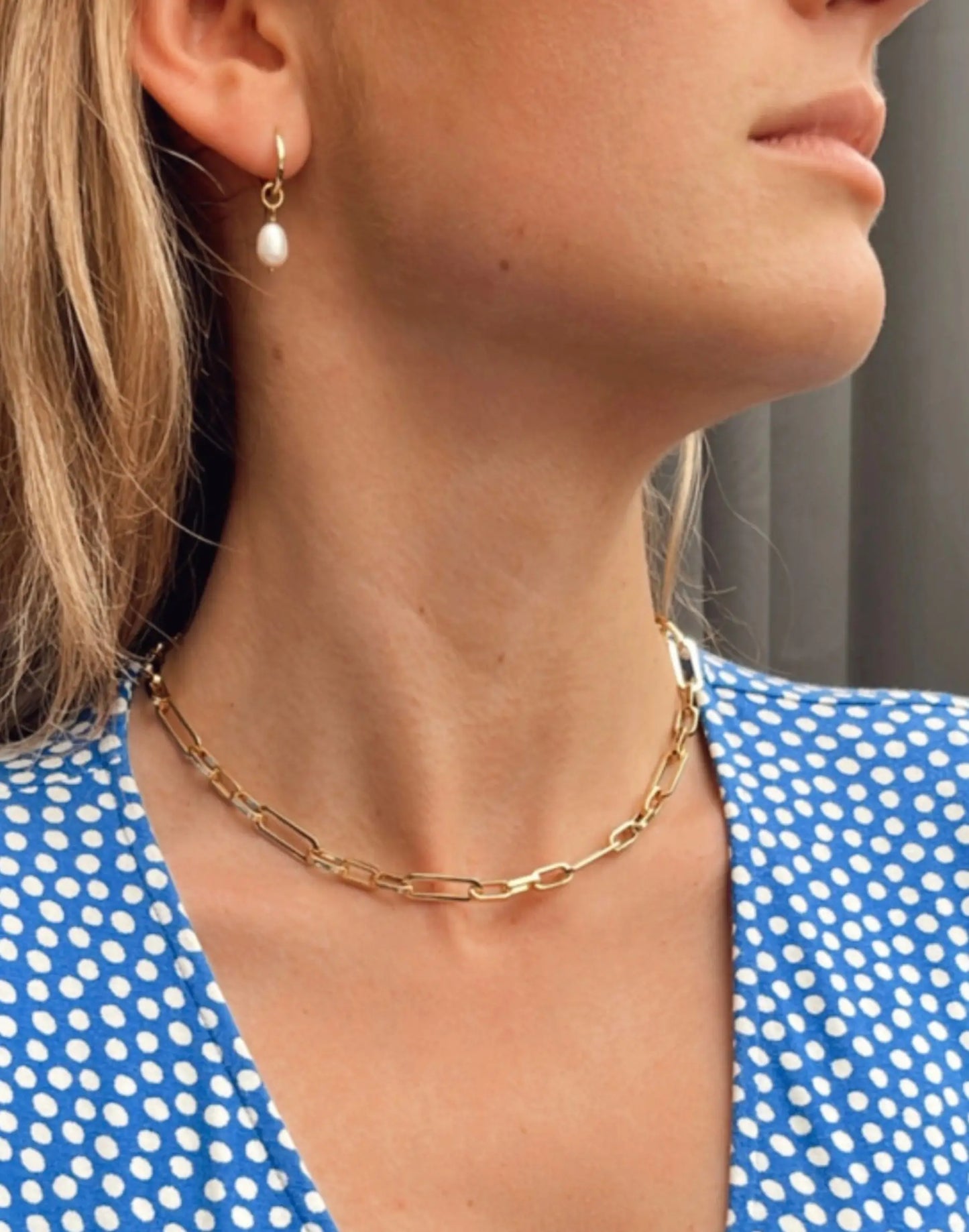 Kitty Gold pearl charm huggies on model in ear