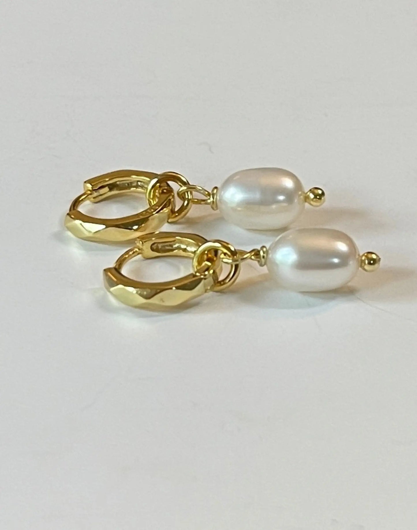 Kitty Gold pearl charm huggies on white background
