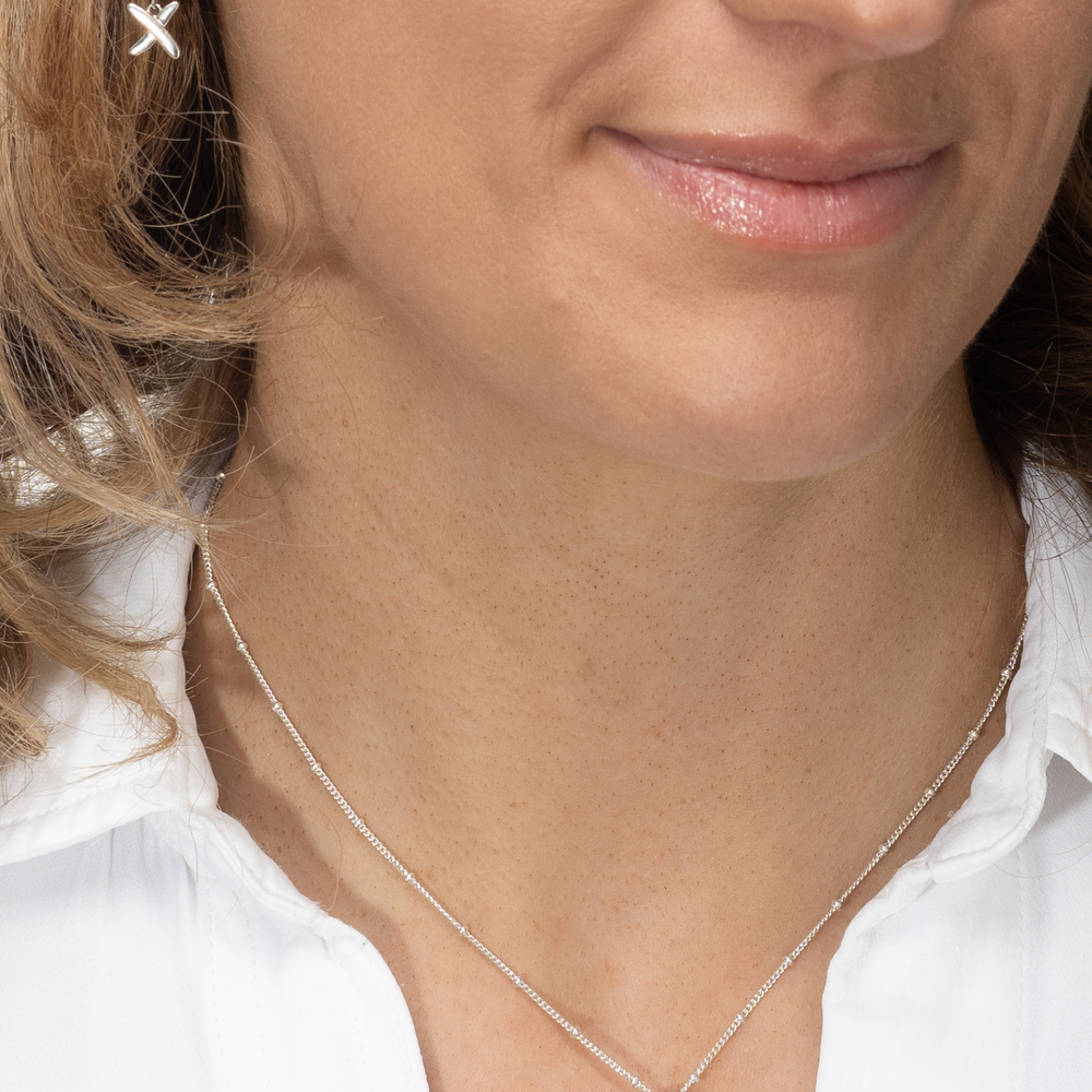 
                  
                    model wears silver kiss huggies with silver necklace
                  
                