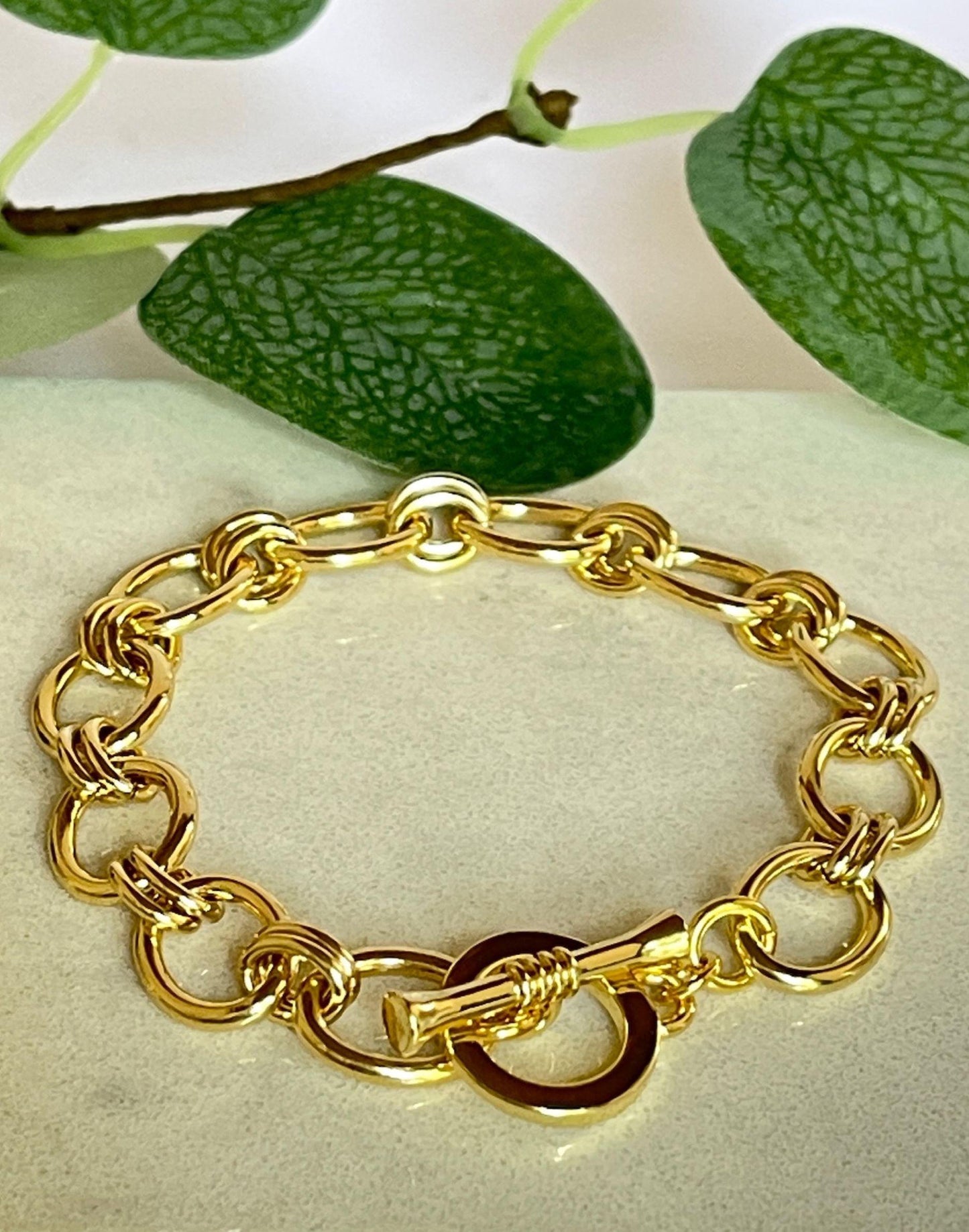 Lizzy gold link bracelet on a tile