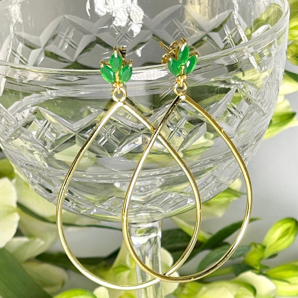 
                  
                    Lotus flower green onyx gold earrings on glass
                  
                