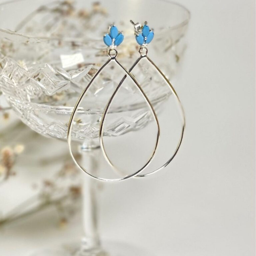
                  
                    Lotus flower silver turquoise drop earrings on glass
                  
                