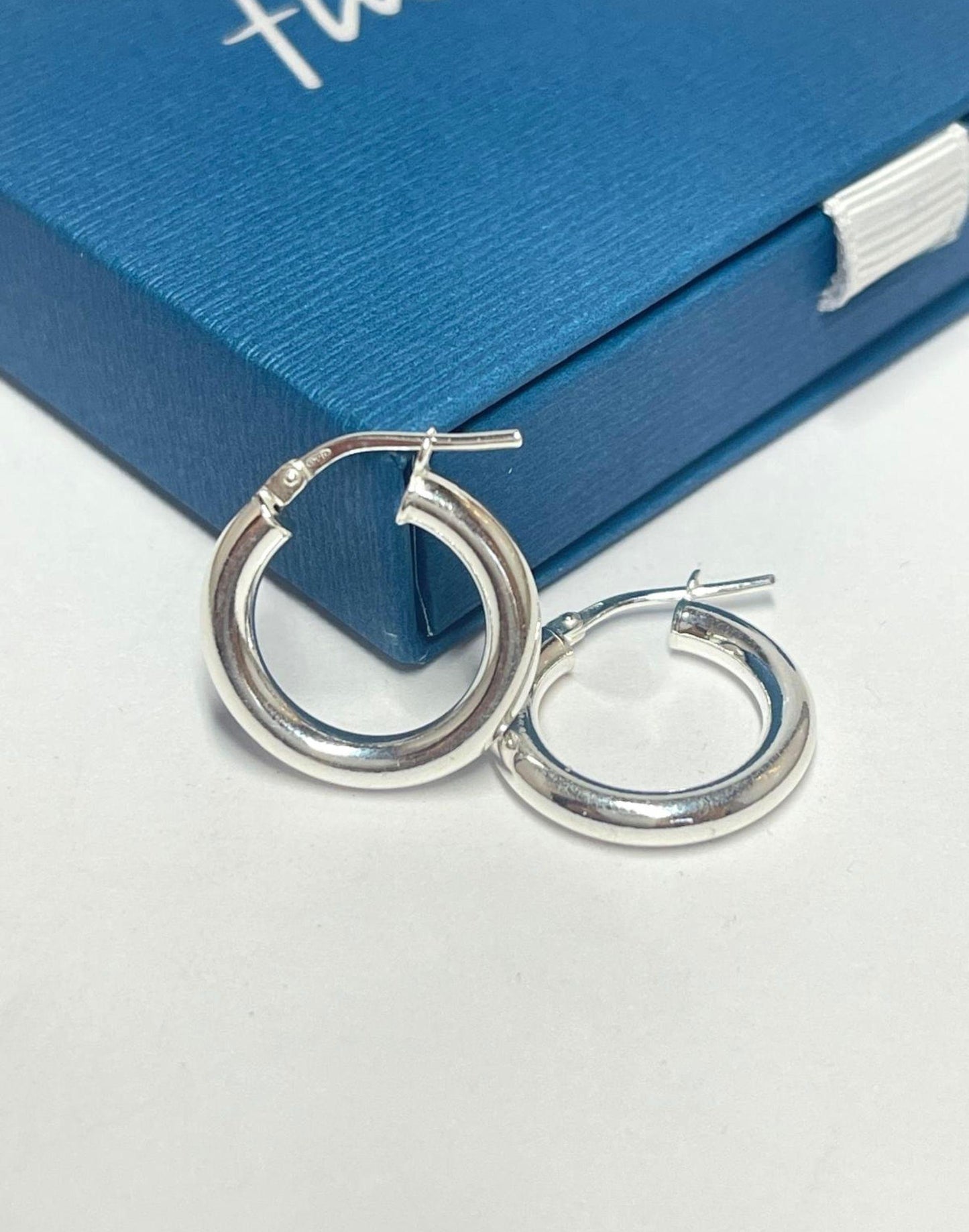 mid-sized silver hoop earrings on a Flutterby gift box