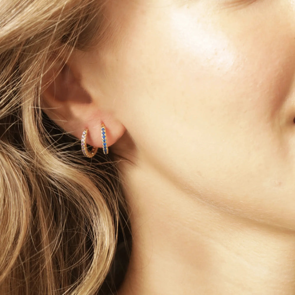 Model wearing two birthstone huggies