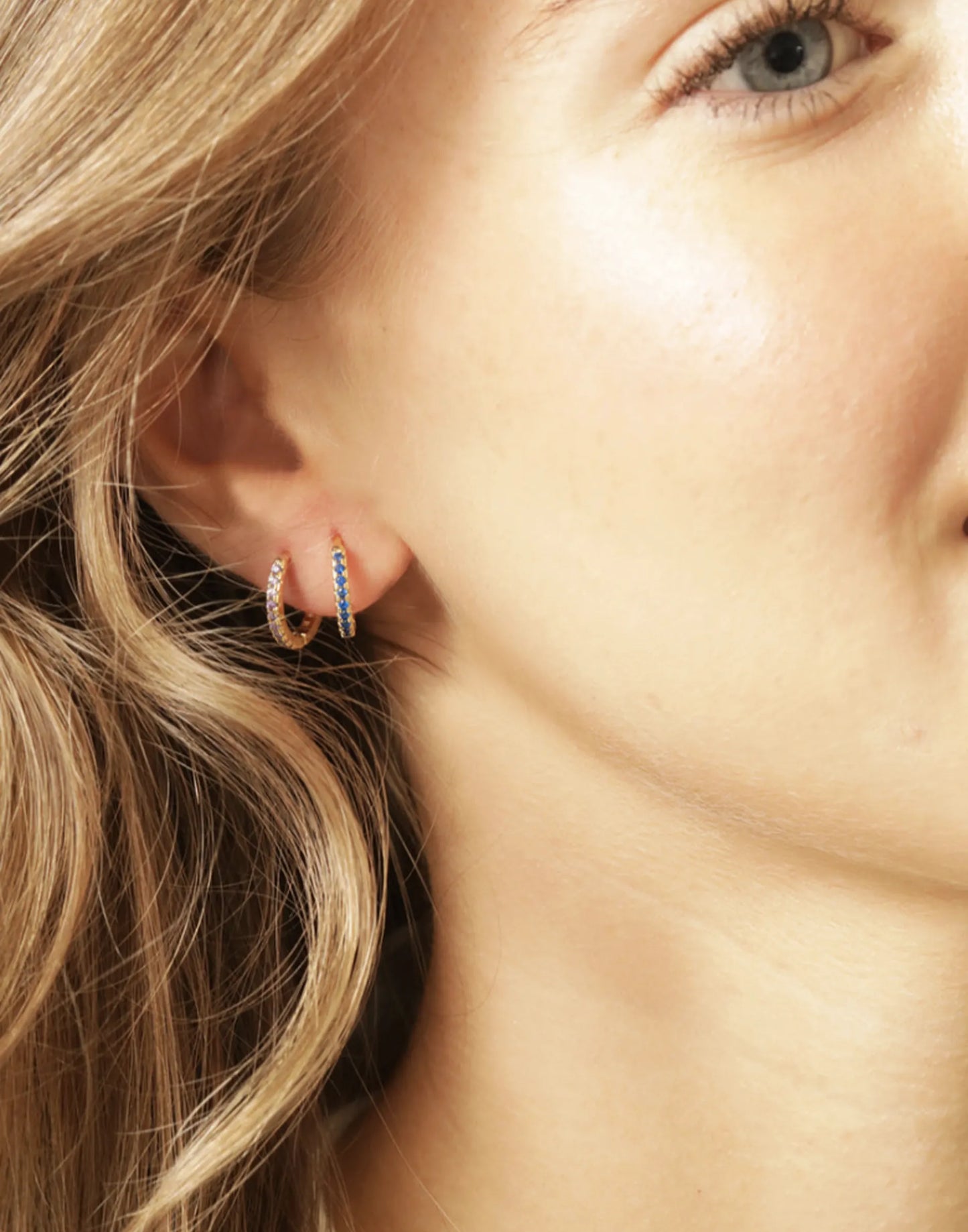 Model wearing two birthstone huggies