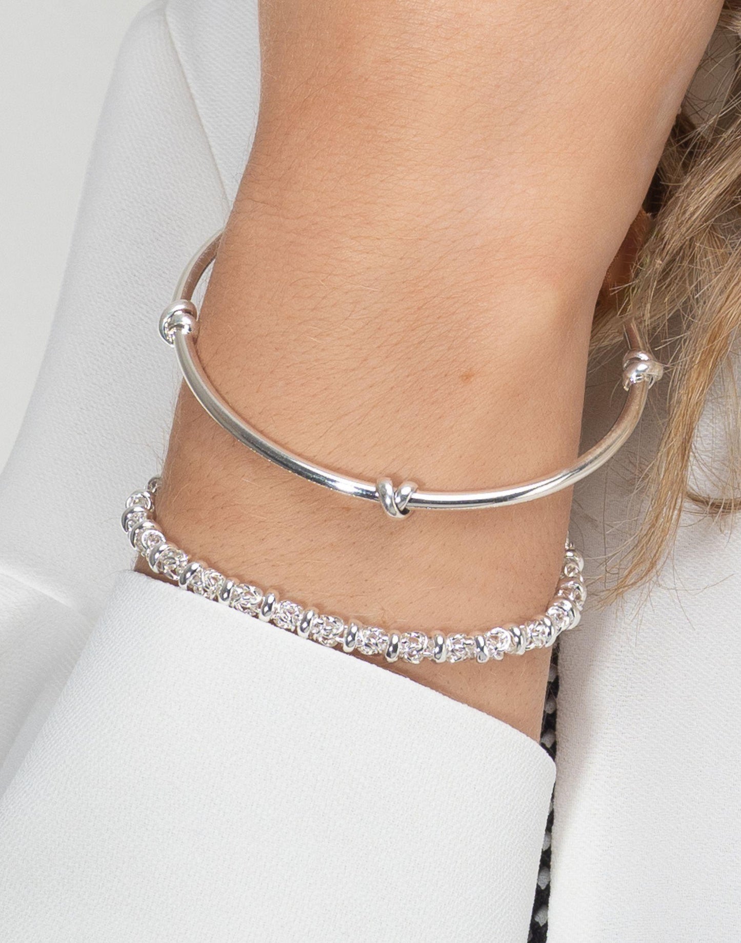 Model wears morton silver knot bangle with silver dee bracelet