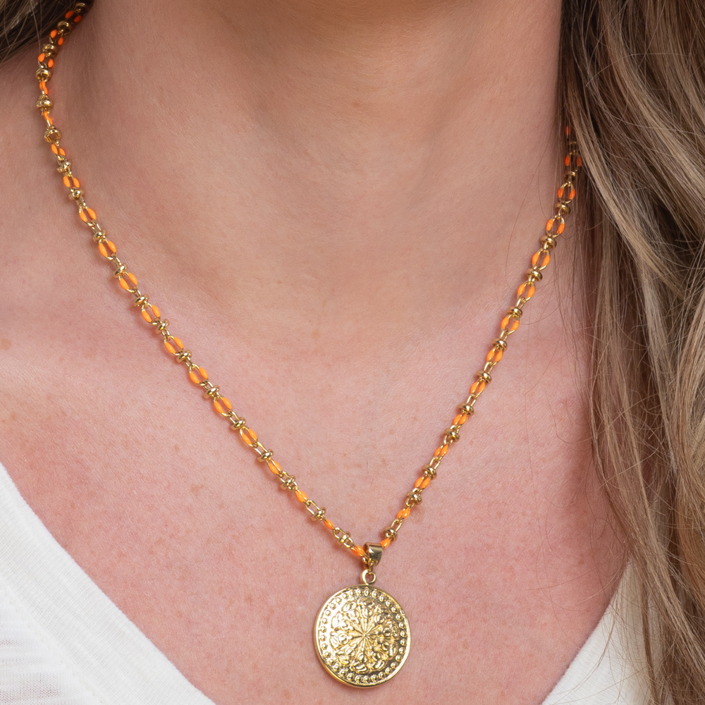 
                  
                    Orange enamel necklace with large gold charm
                  
                
