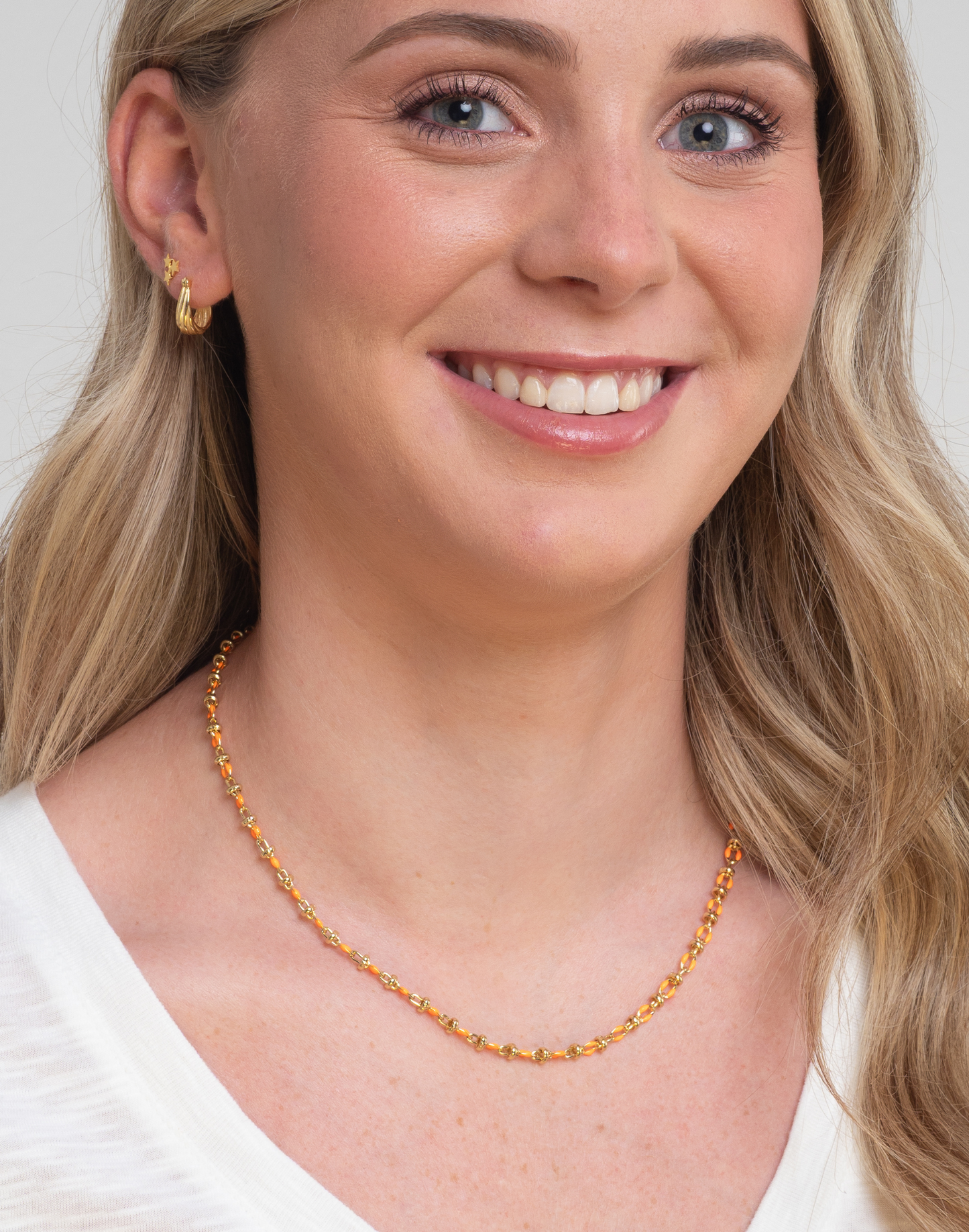 orange enamel necklace on model