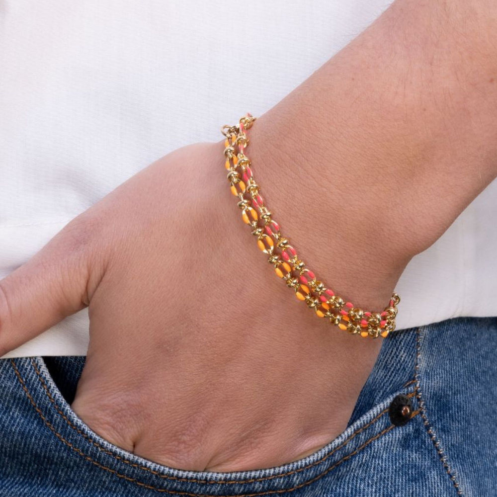 
                  
                    Model wears stack of orange and pink enamel bracelets
                  
                