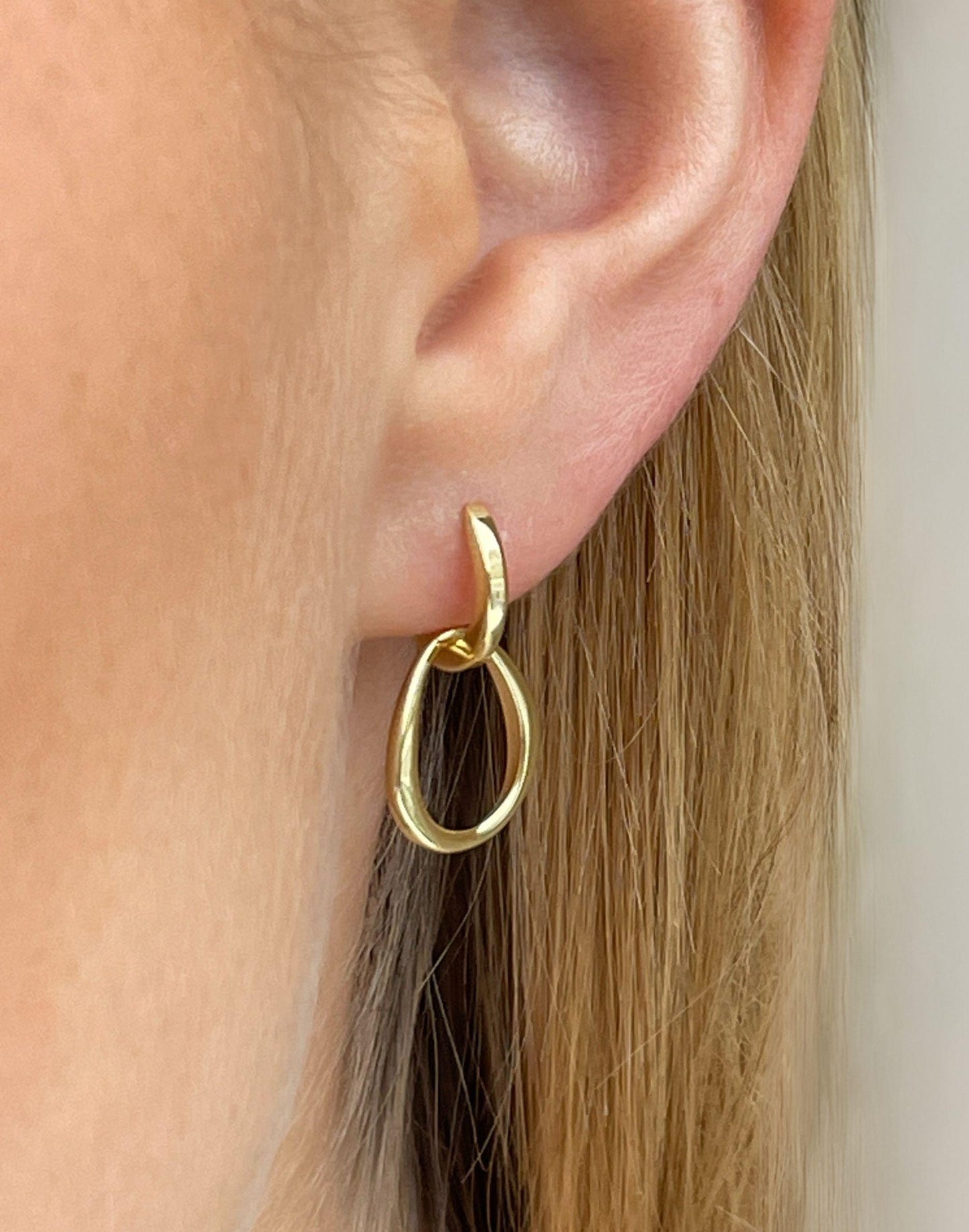 model wears organic charm gold huggie earrings