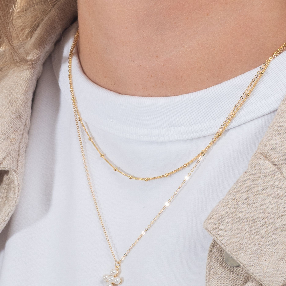 
                  
                    Gold pearl cross layered with gold necklace
                  
                