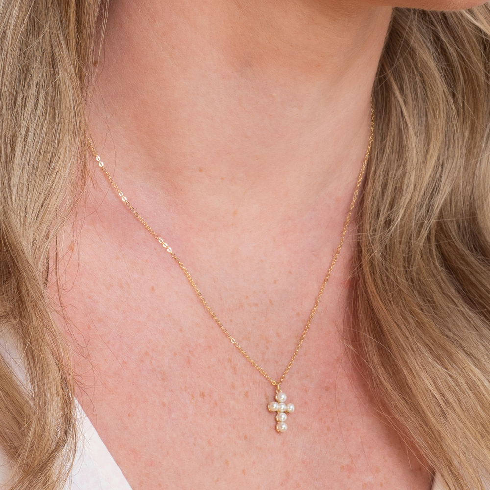 
                  
                    model wears gold pearl cross necklace 
                  
                