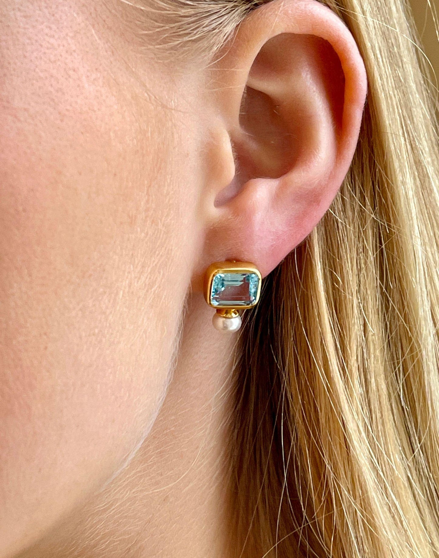 model wears pearl and blue topaz stud earrings