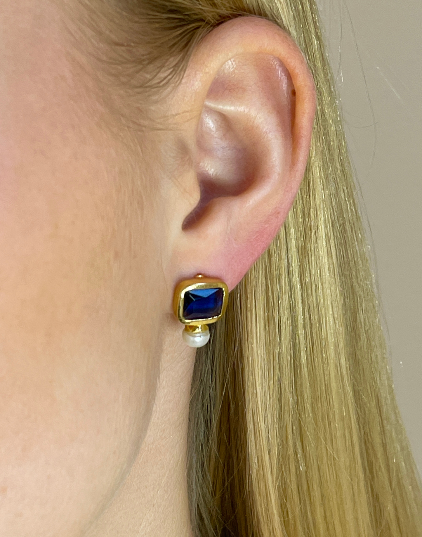 model wears pearl and navy stud earrings