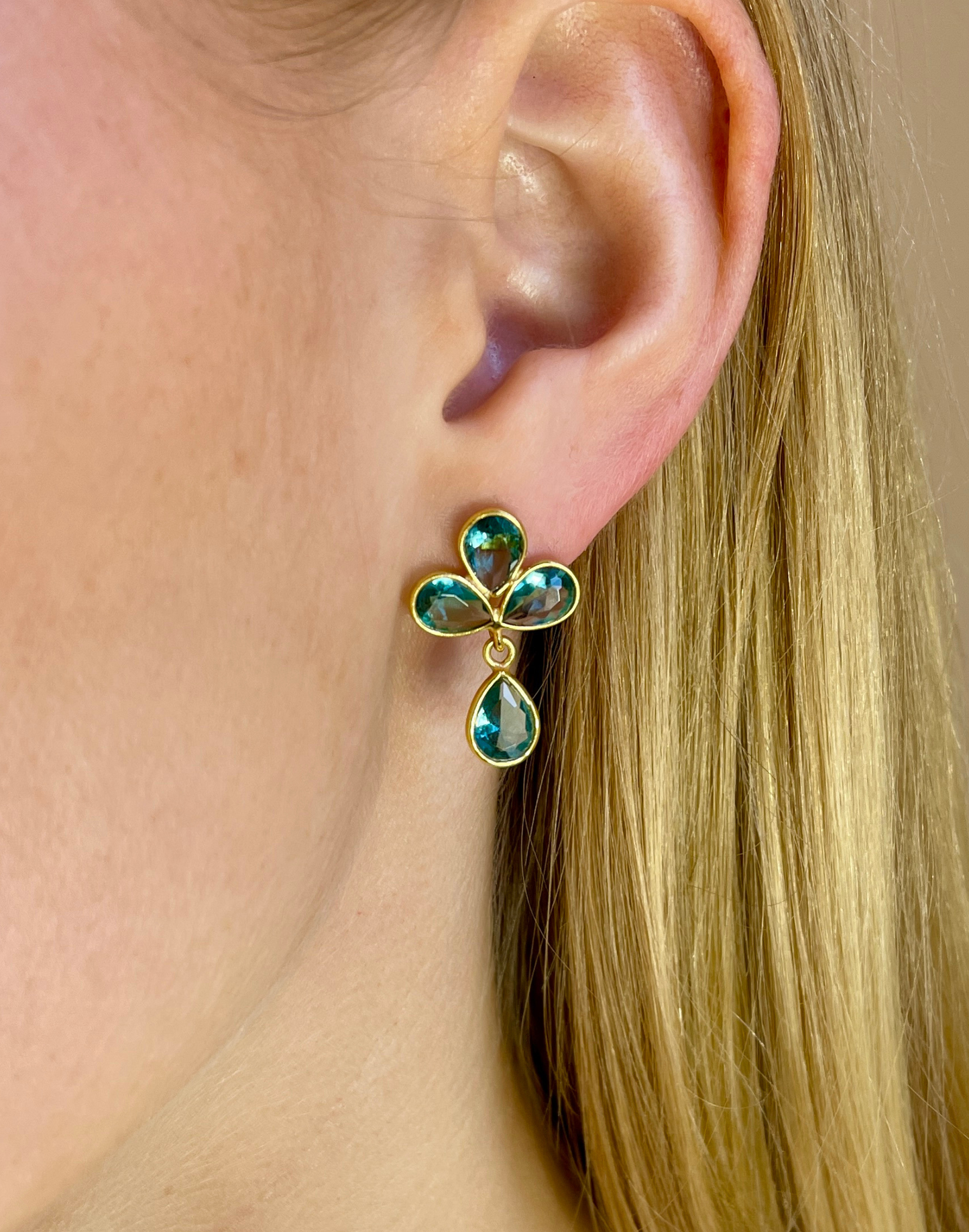 Model wears petal blue topaz drop earrings