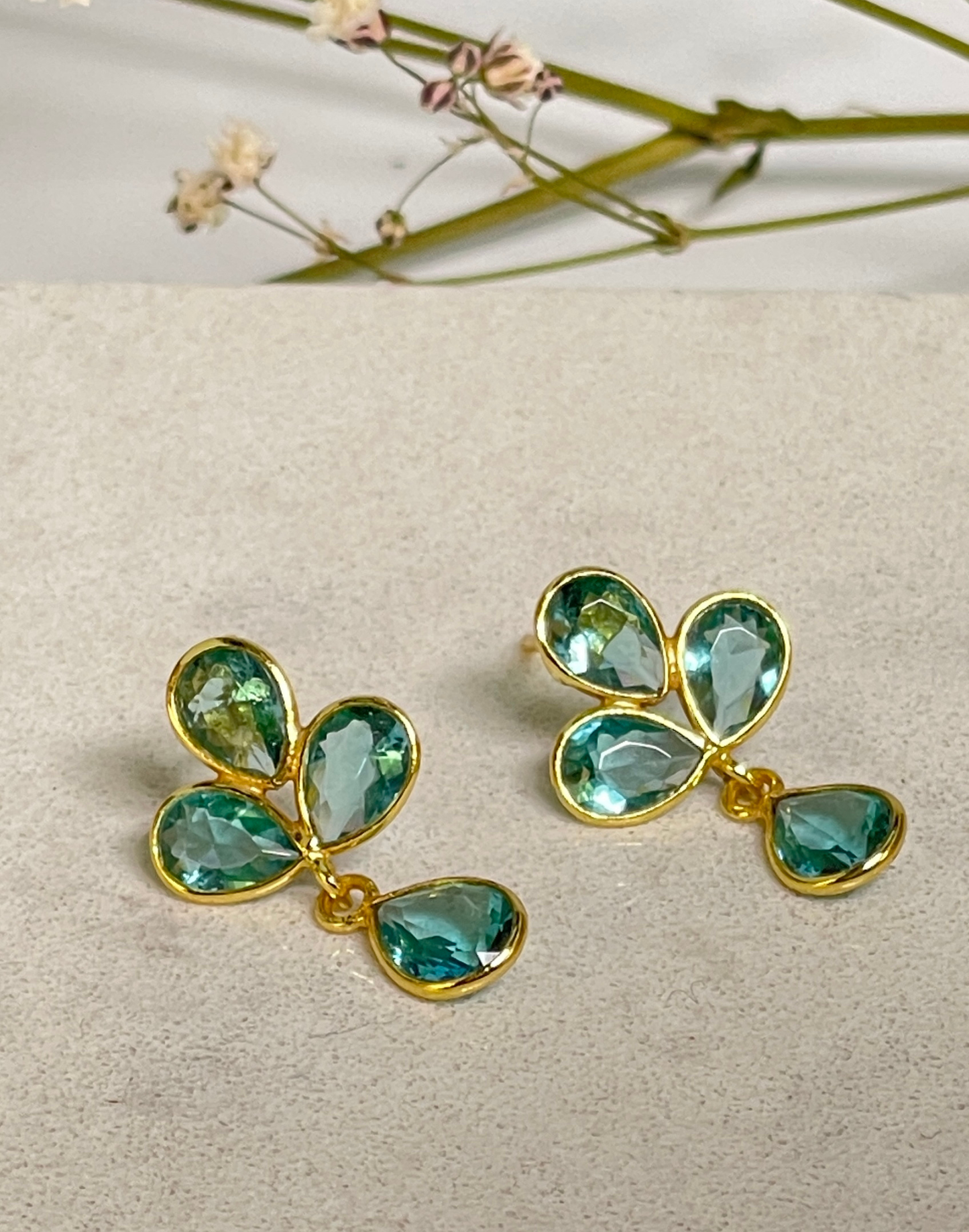 blue topaz petal earrings on tile