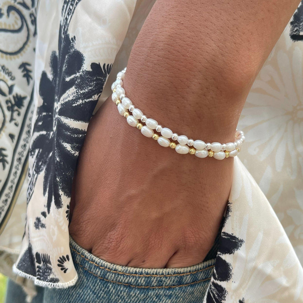 
                  
                    Model wears Sadie Pearl and Silver Bracelet with hand tucked into jeans
                  
                