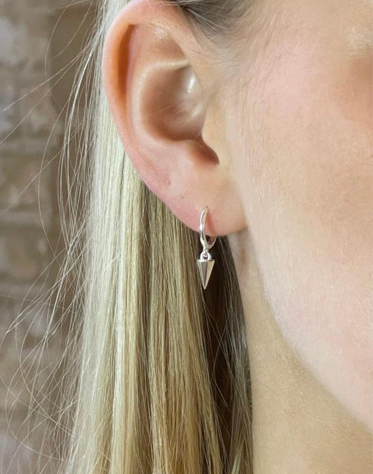 model wears short cone silver huggie earrings