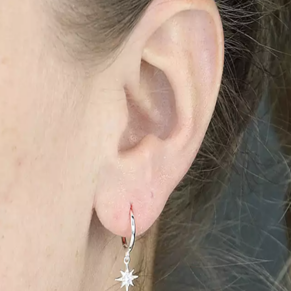 
                  
                    model wears silver cz star charm huggies
                  
                