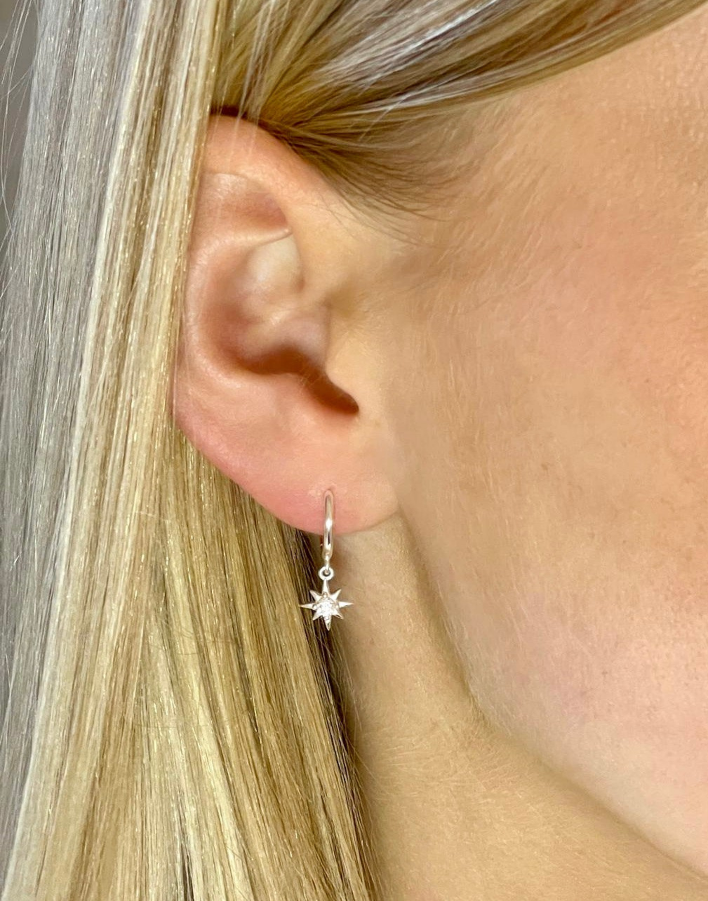 Model wears Silver CZ Star Charm Huggie Earrings 
