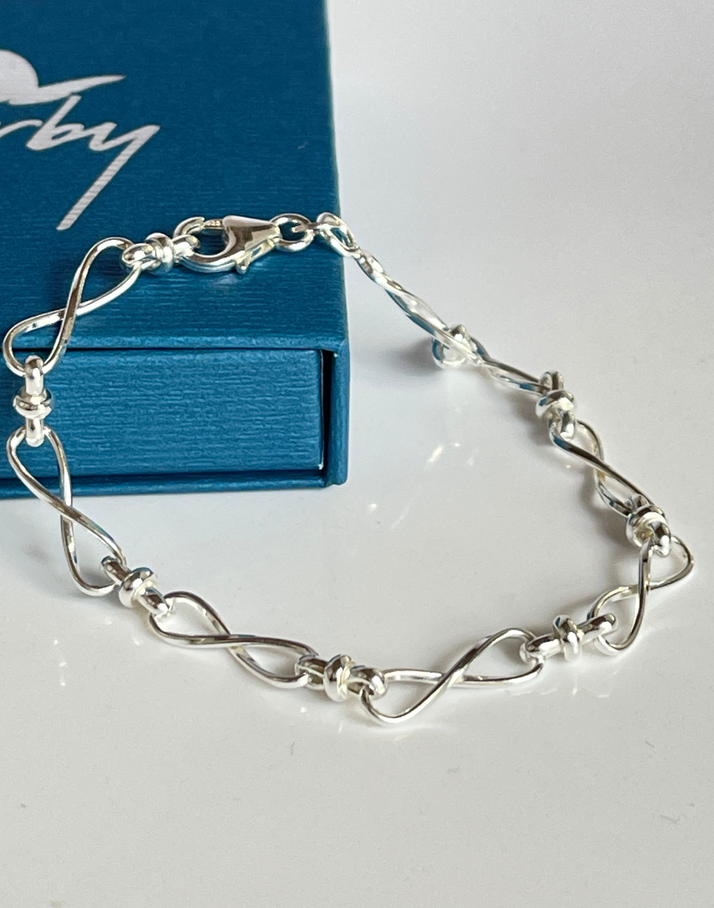 silver infinity bracelet on tile